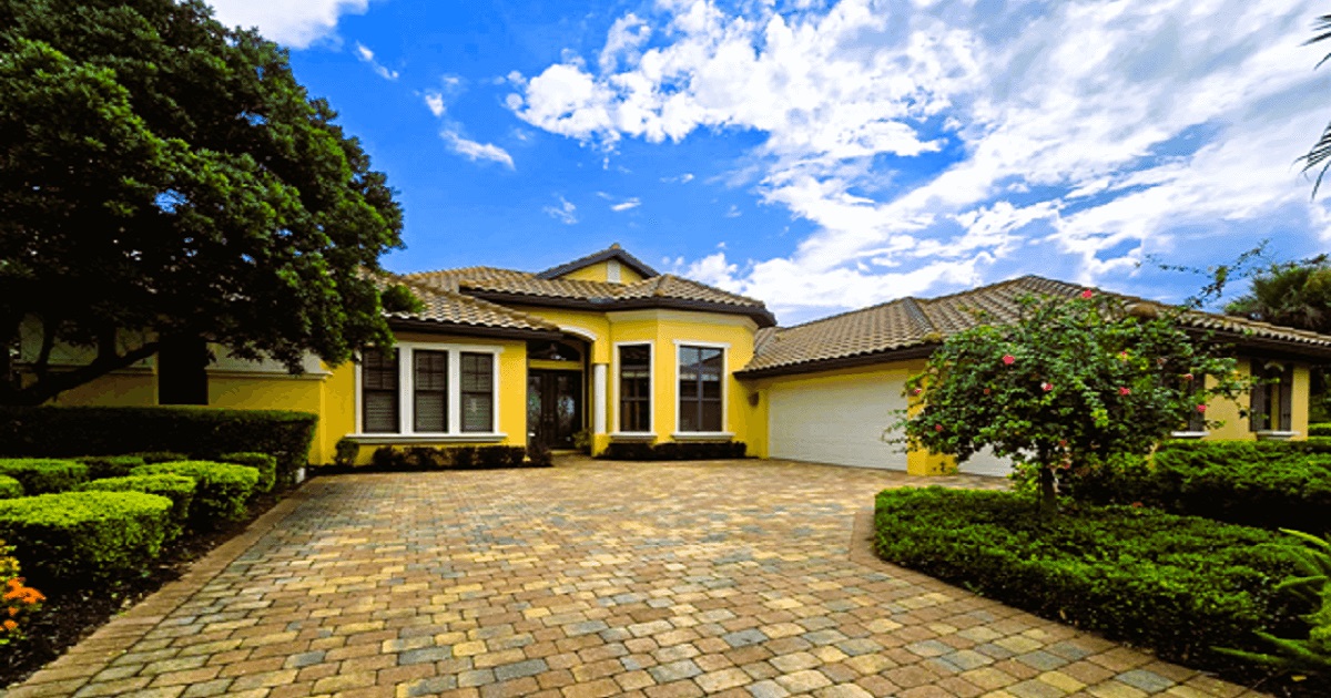 Professional home inspector examining a Fort Myers Florida property with a waterfront view for wind mitigation and structural issues
